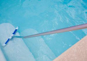 Reparando el liner y después limpiándolo de una piscina