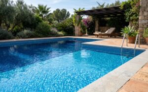 fotografía realista de una piscina con liner mostrando diferentes tonalidades según la iluminación, contraste entre zonas iluminadas y en sombra, agua limpia y superficie tranquila, entorno exterior, estilo fotografía profesional, alta calidad, sin texto, sin gráficos, sin iconos, enfoque nítido, textura realista