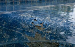 detalle de pequeños daños y arañazos sobre un liner de piscina